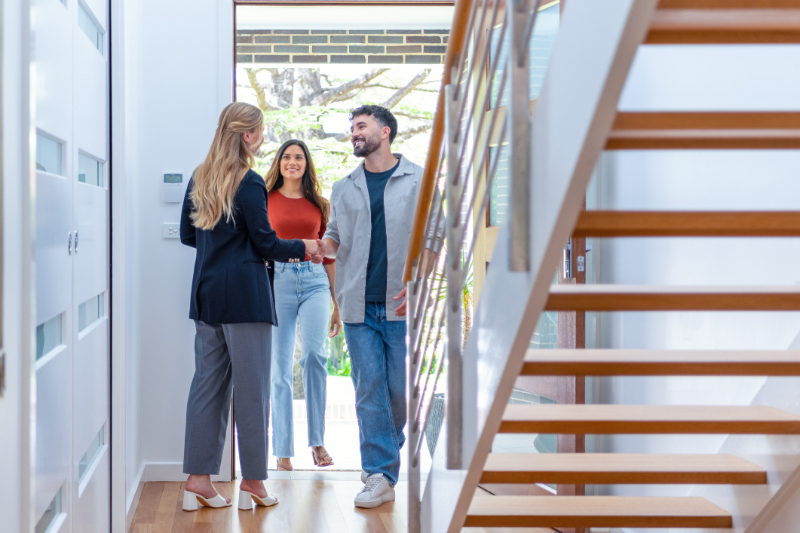 Real estate agent showing a young couple a new house